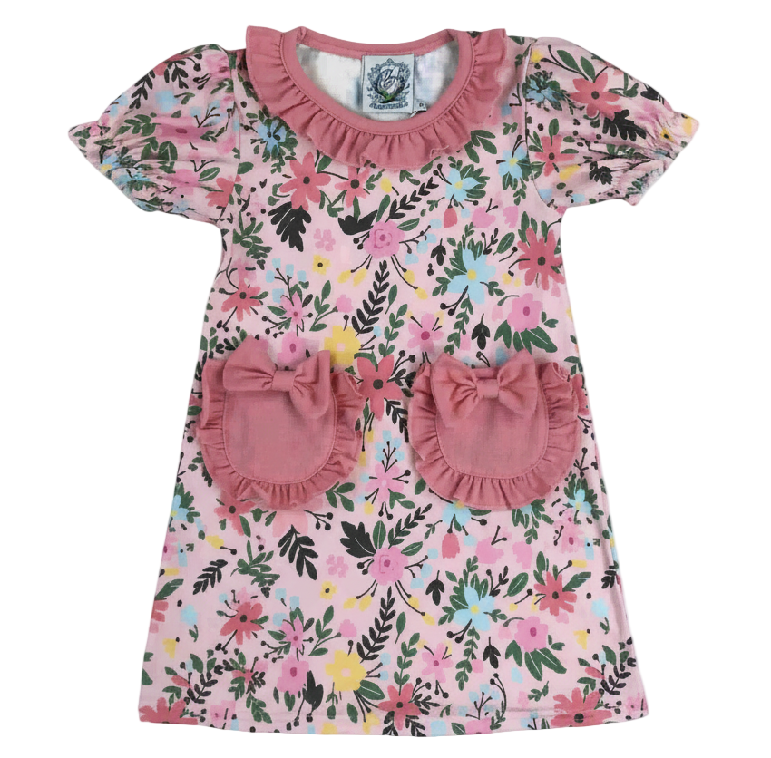 Field Of Flowers Spring Pocket Dress featuring a pink floral print, ruffled neckline, puff sleeves, and two front pockets accented with bows.