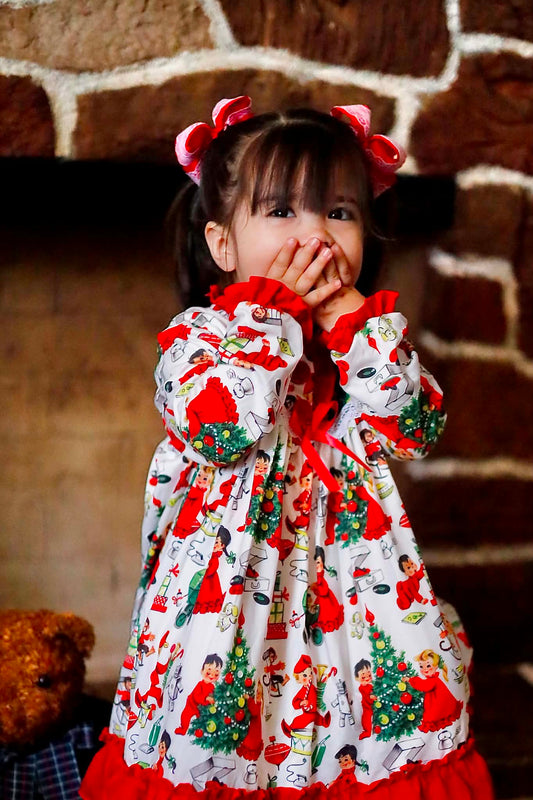 Toddler girl wearing Antique Christmas Morning Child's Play Nightgown covering mouth in excitement by fireplace.