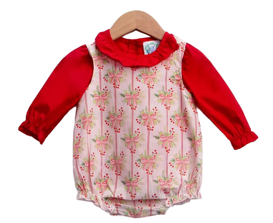 Baby girl holiday romper featuring long red sleeves, a ruffled collar, and a pink bow and greenery pattern.