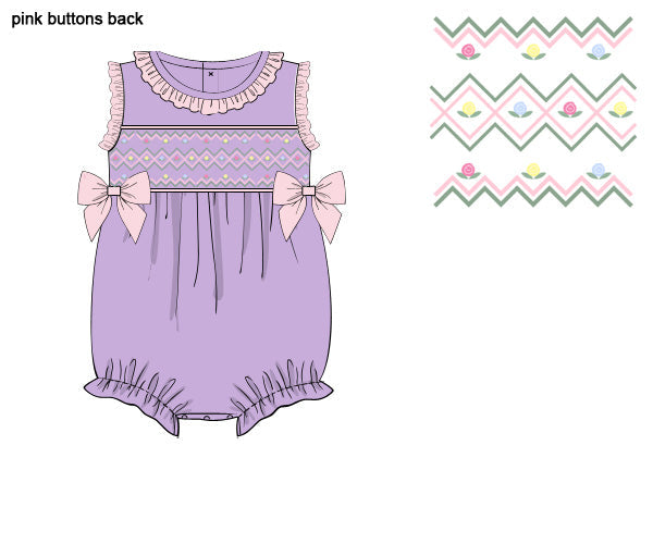 Lavender hand-smocked girls bubble romper with baby pink ruffle trim, side bows, and pastel flower embroidery.