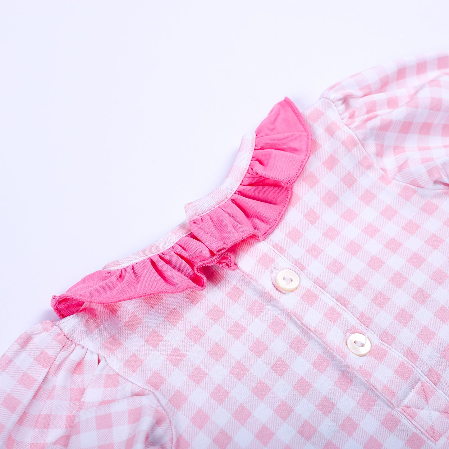 Close-up shot of back button closure and pink ruffle collar on Little Sister hand smocked gingham sleep sack.