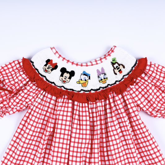 Close-up of white hand smocked collar featuring embroidered cartoon characters on red gingham baby girl dress.