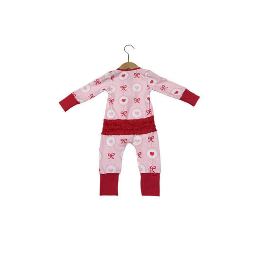 Back view of pink Valentine's Day heart and bow girl zippy romper featuring red smocked ruffled waist.