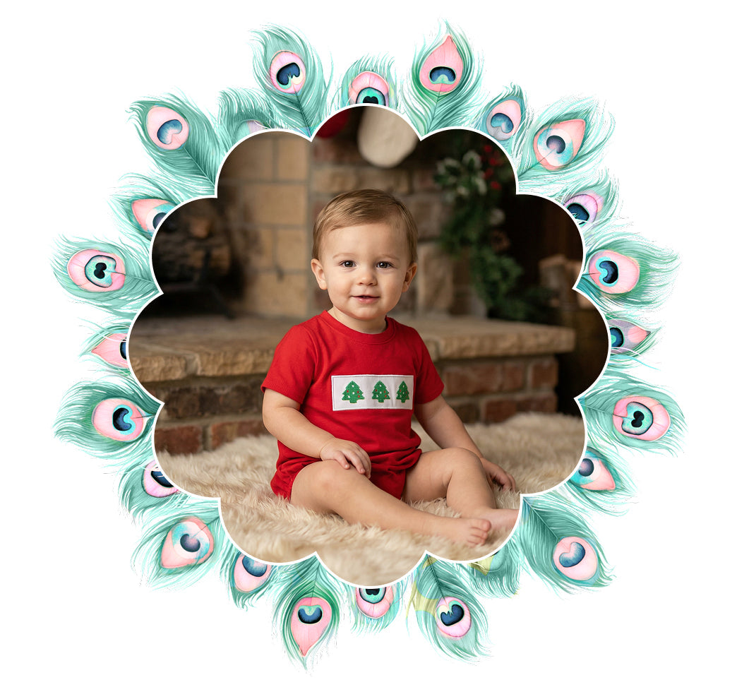 Baby boy in red Christmas tree smocked bubble romper sitting by a fireplace for boys bubble collection.