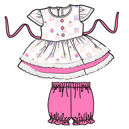 Children's outfit with a patterned top and pink shorts on a white background
