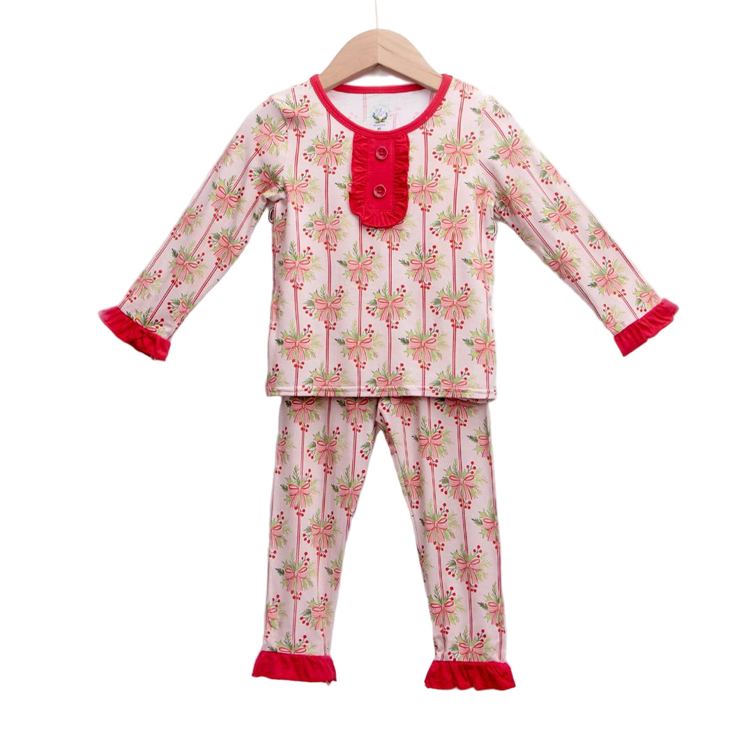 Pink bamboo Christmas pajama set featuring a festive pattern of bows, holly berries, and red ruffle trim.