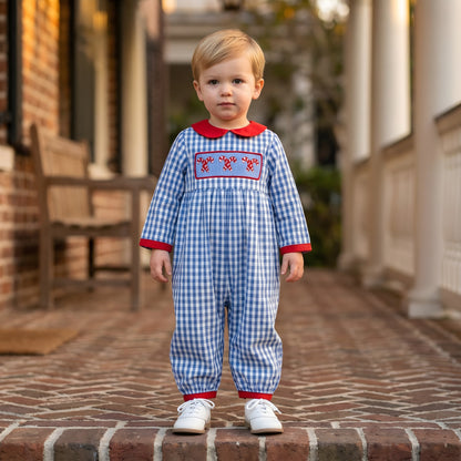 Toddler wearing a blue gingham Boys Hand Smocked Christmas Candy Cane Romper with red collar and cuffs.