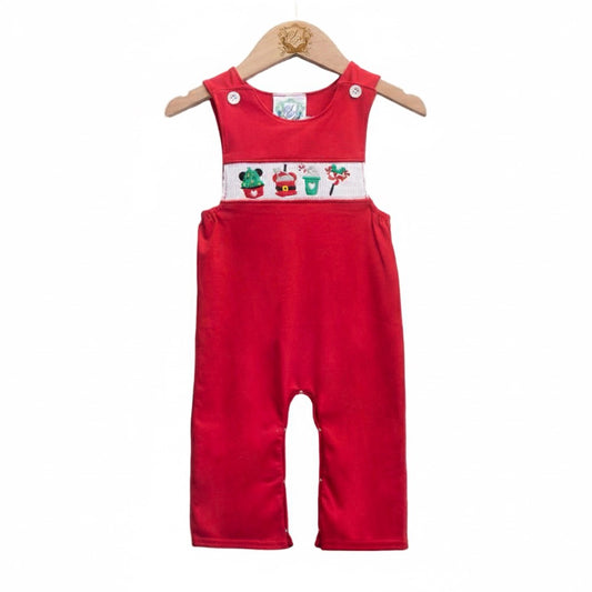 A sleeveless, bright red knit Jon Jon hanging on a wooden hanger against a white background. The garment features white buttons on the shoulder straps and a white smocked panel across the chest embroidered with holiday sweet treats, including a Christmas tree cupcake, a Santa-themed dessert, a green hot cocoa mug, and a lollipop.