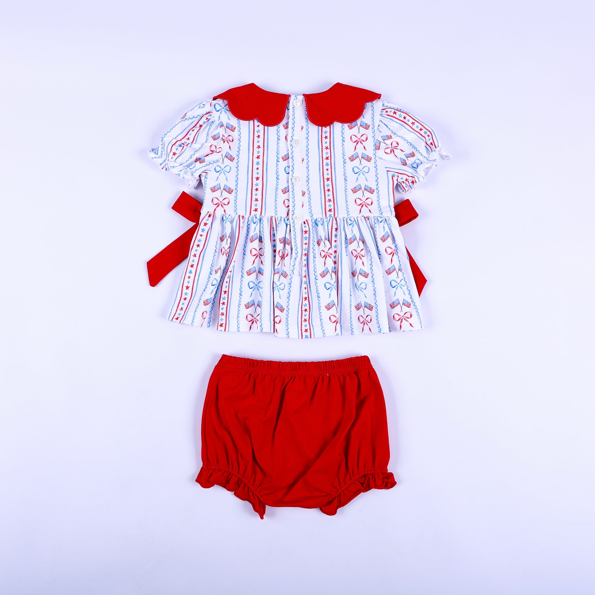Back view of America the Beautiful smocked diaper set showing button closure top and red elastic bloomer bottoms.