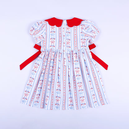 Full back view of America the Beautiful hand smocked dress showing button closure and tied red side sashes.