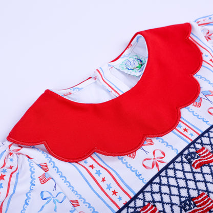 Close-up of vibrant red scalloped Peter Pan collar on America the Beautiful hand smocked embroidered dress for kids.