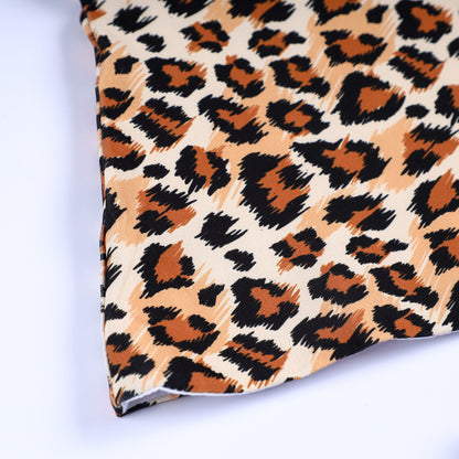 Close-up of premium safari animal kingdom leopard print fabric and hem stitching on smocked top outfit.