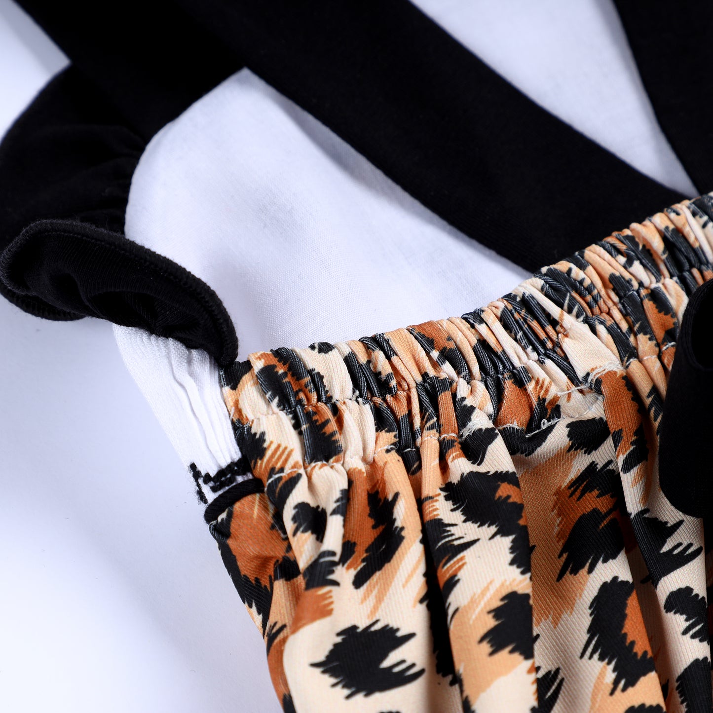 Detailed view of elastic back waistband and black ruffle strap on leopard print safari mouse smocked bubble romper.