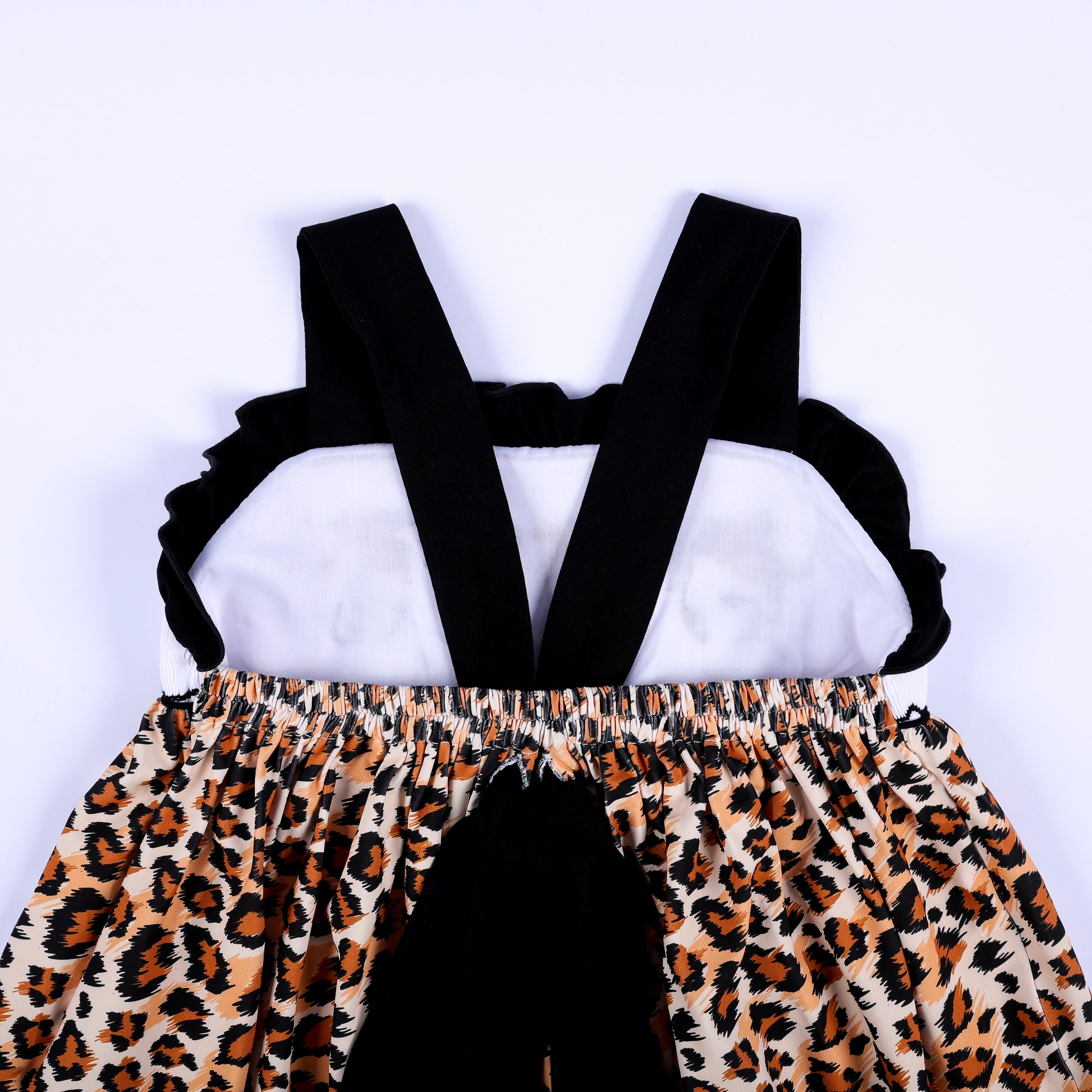 Back bodice close up view of a safari mouse hand smocked dress showing black criss cross straps and tie bow.