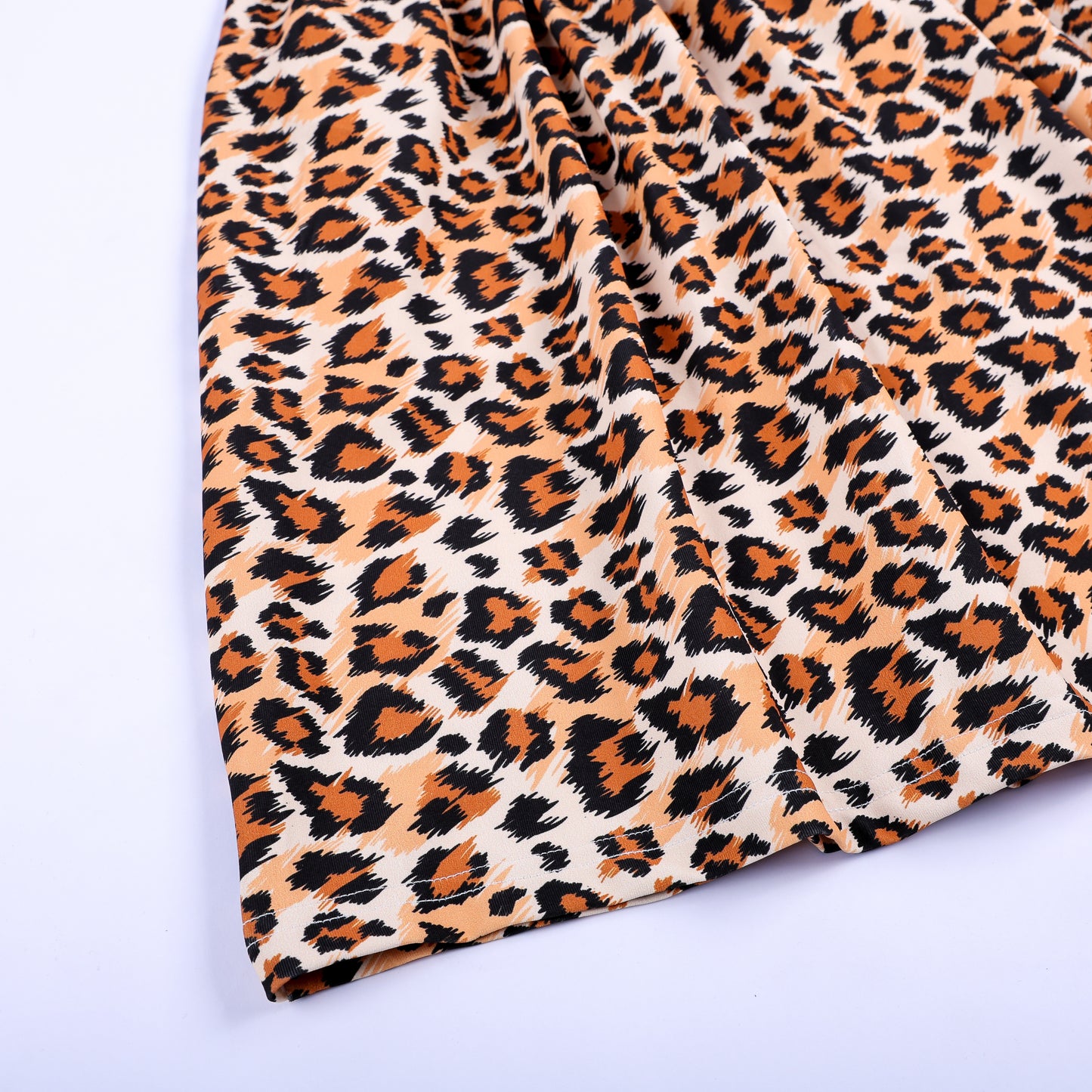 Close up texture detail of leopard animal print fabric skirt on a hand smocked safari mouse girls dress.