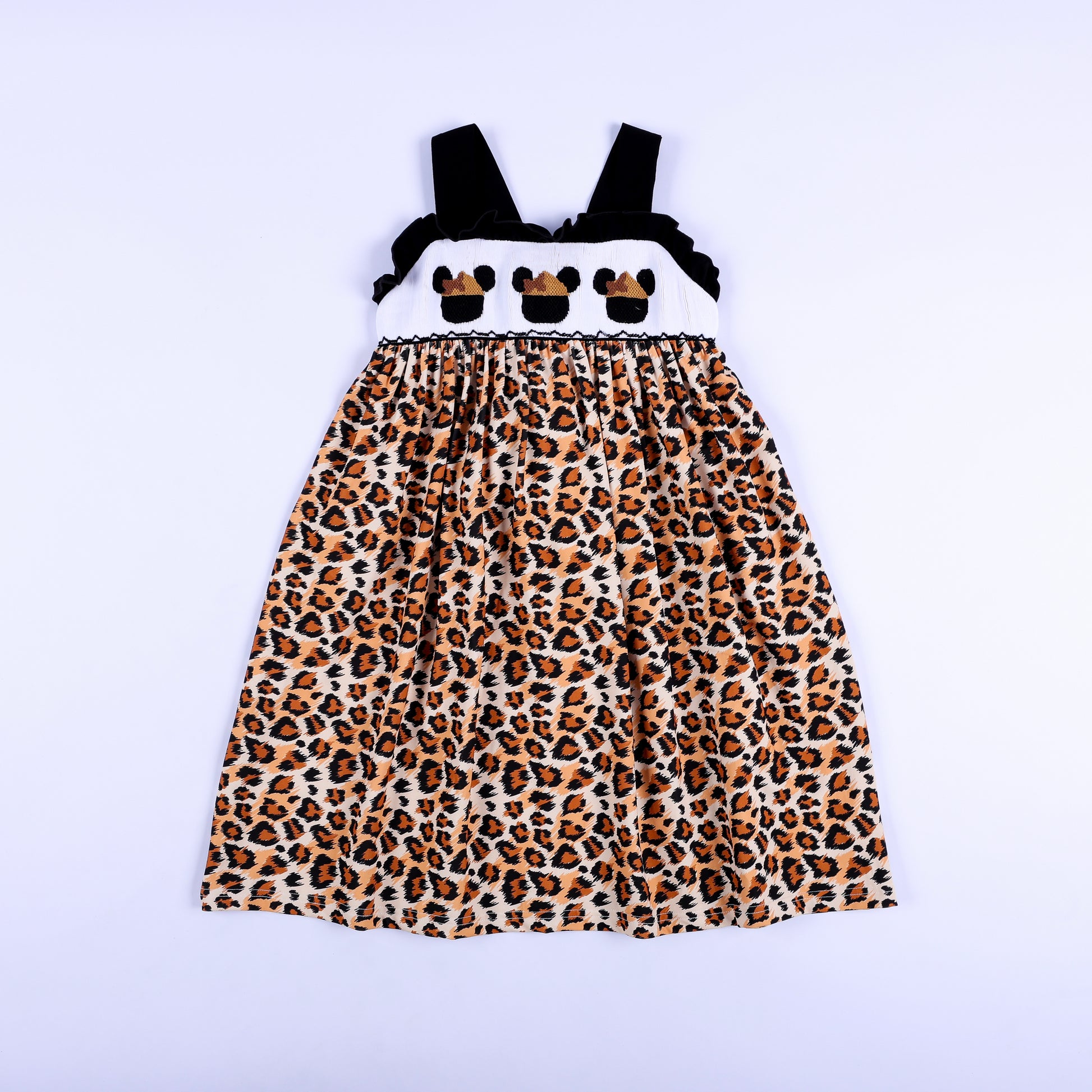 Full front view of a girls animal print safari mouse hand smocked dress featuring black shoulder straps.