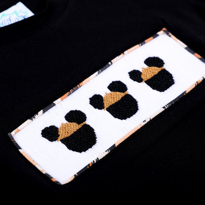 Detailed macro shot of hand embroidered safari mouse heads on hand smocked plate with leopard border.