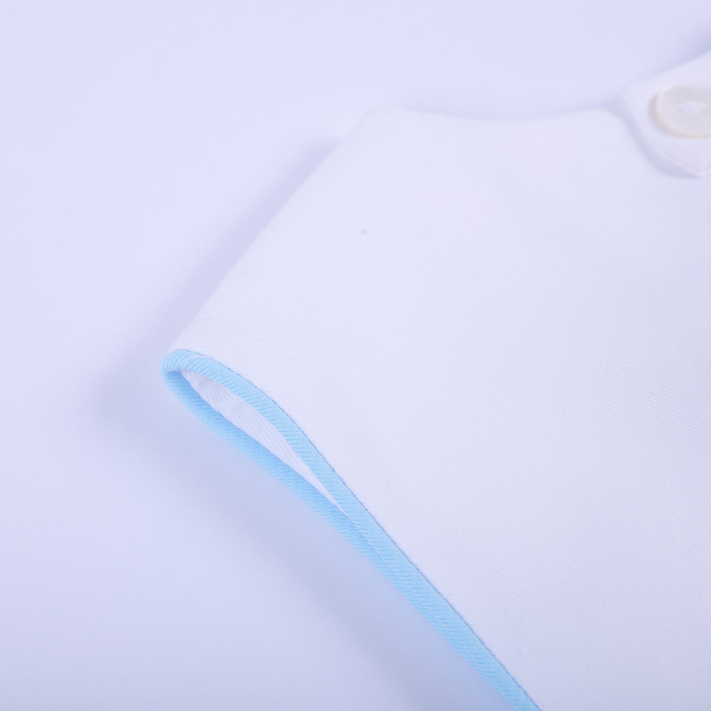 Detailed close-up of soft light blue piped edge piping on sleeveless armhole of baby boy bubble romper.