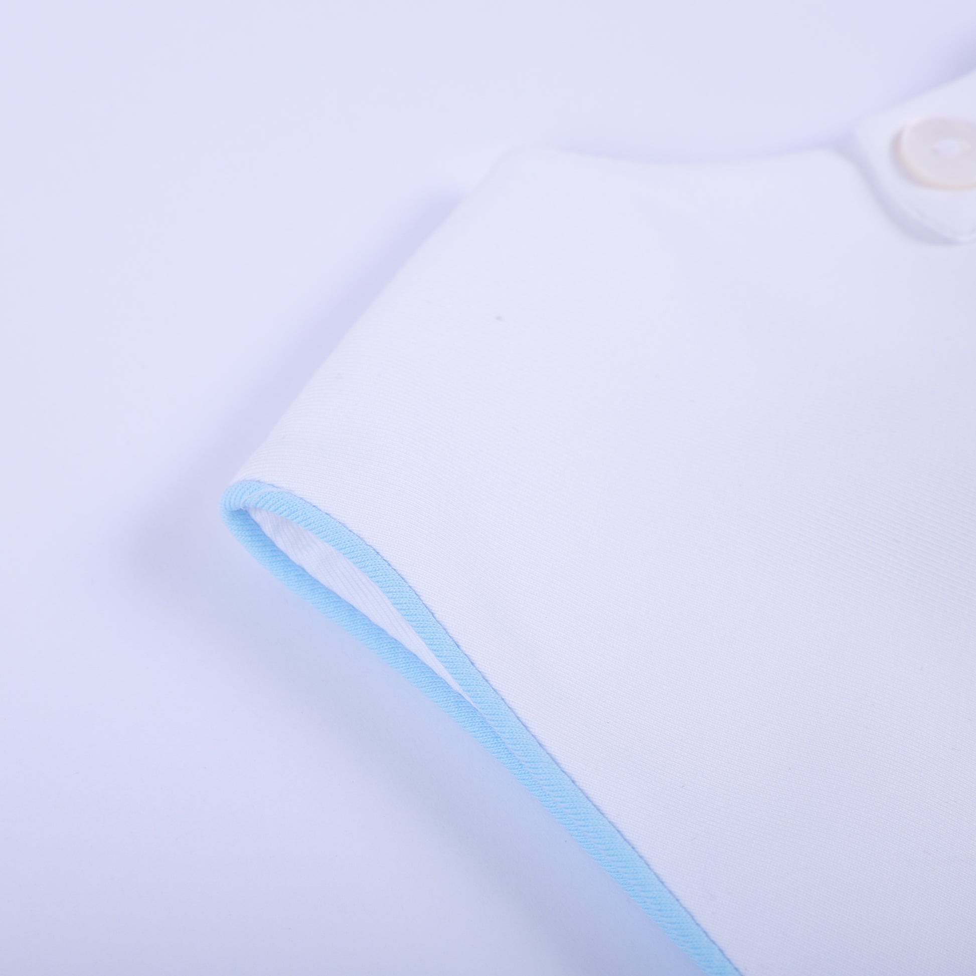 Detailed close-up of soft light blue piped edge piping on sleeveless armhole of baby boy bubble romper.