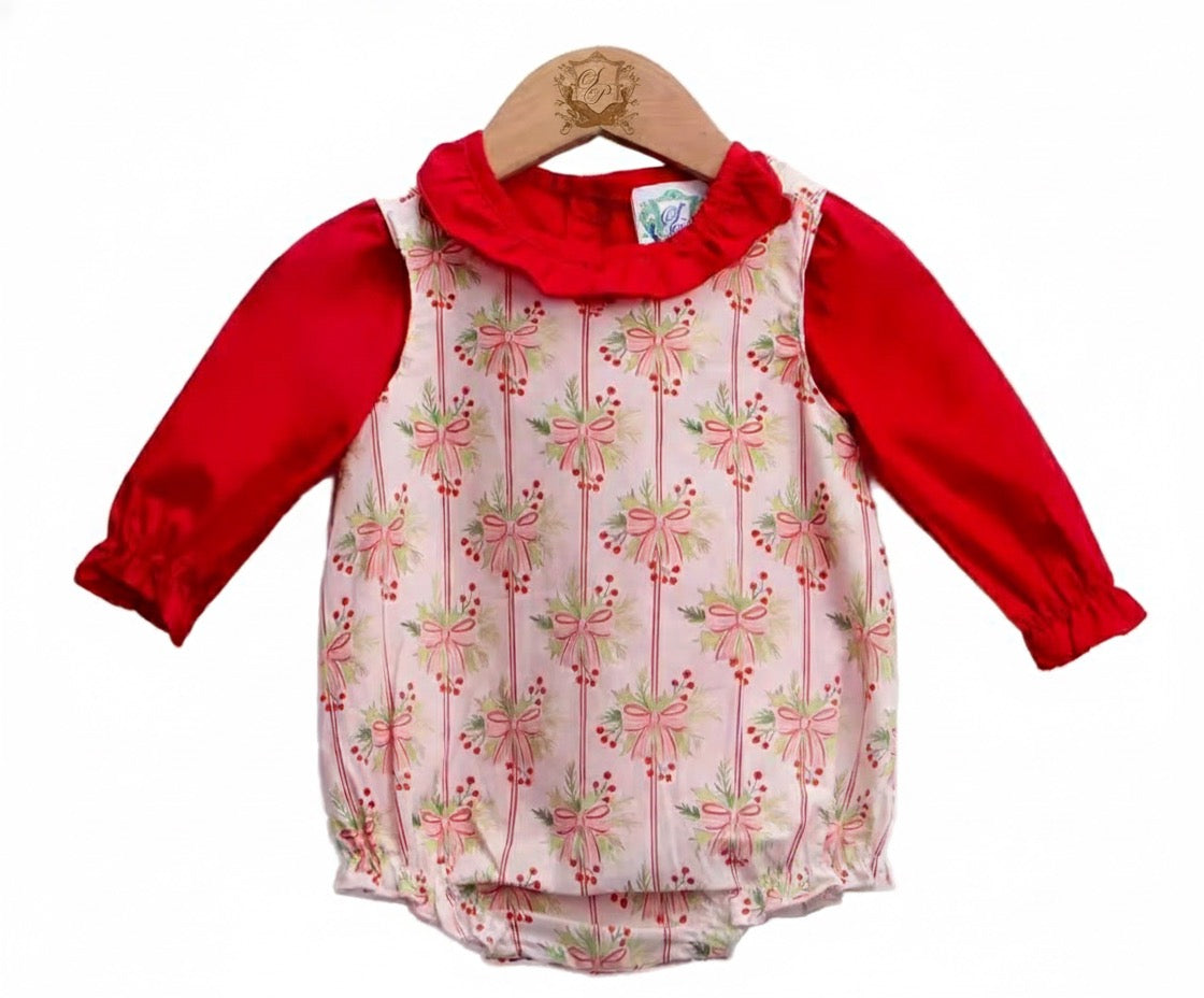 Baby girl holiday romper featuring long red sleeves, a ruffled collar, and a pink bow and greenery pattern.