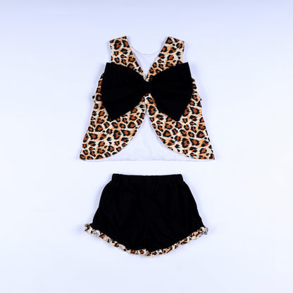 Back view of girls animal kingdom print top with large black bow and matching ruffle hem black shorts.