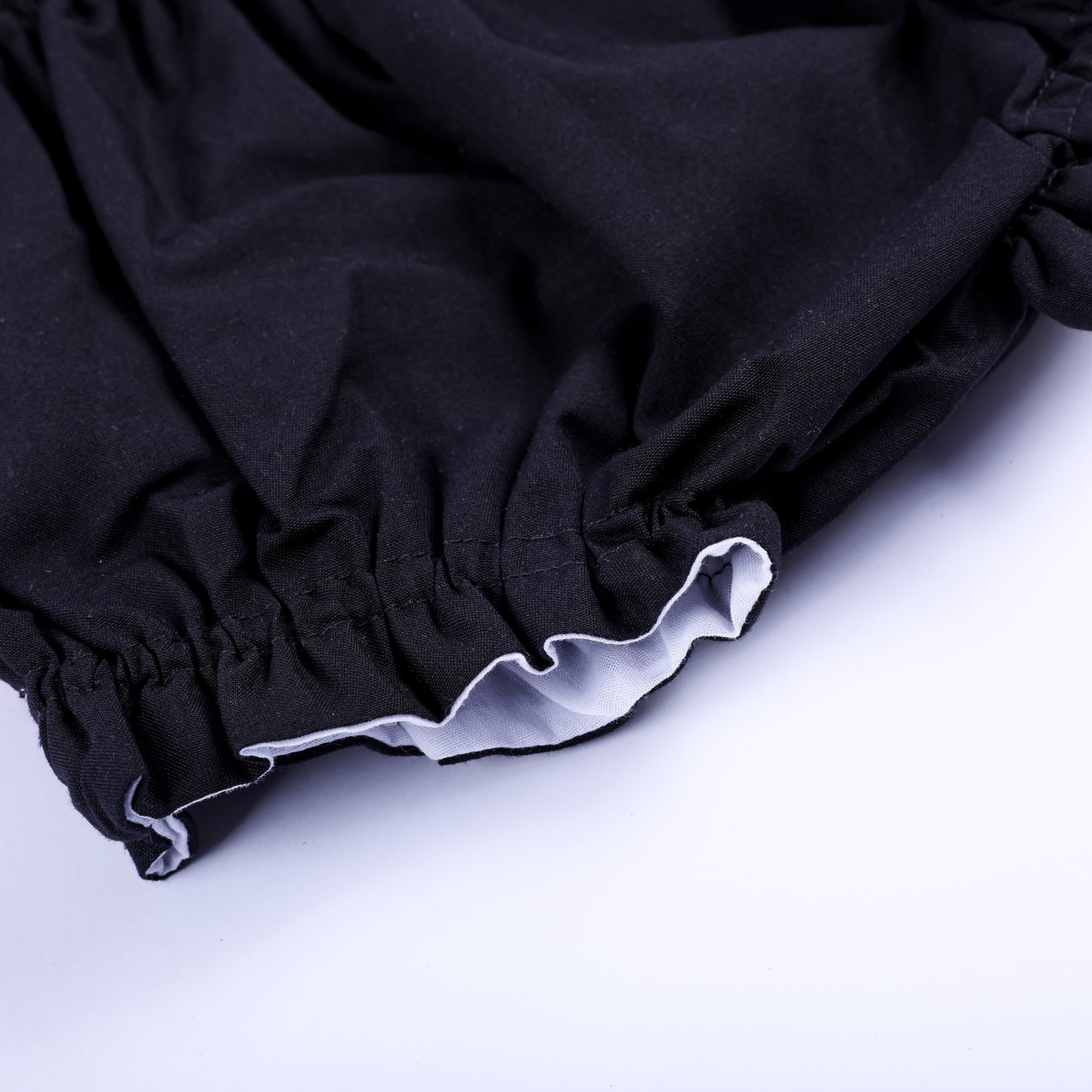 Detailed close-up shot of elastic ruffled leg opening on black baby bloomers from Batty for Bows set.
