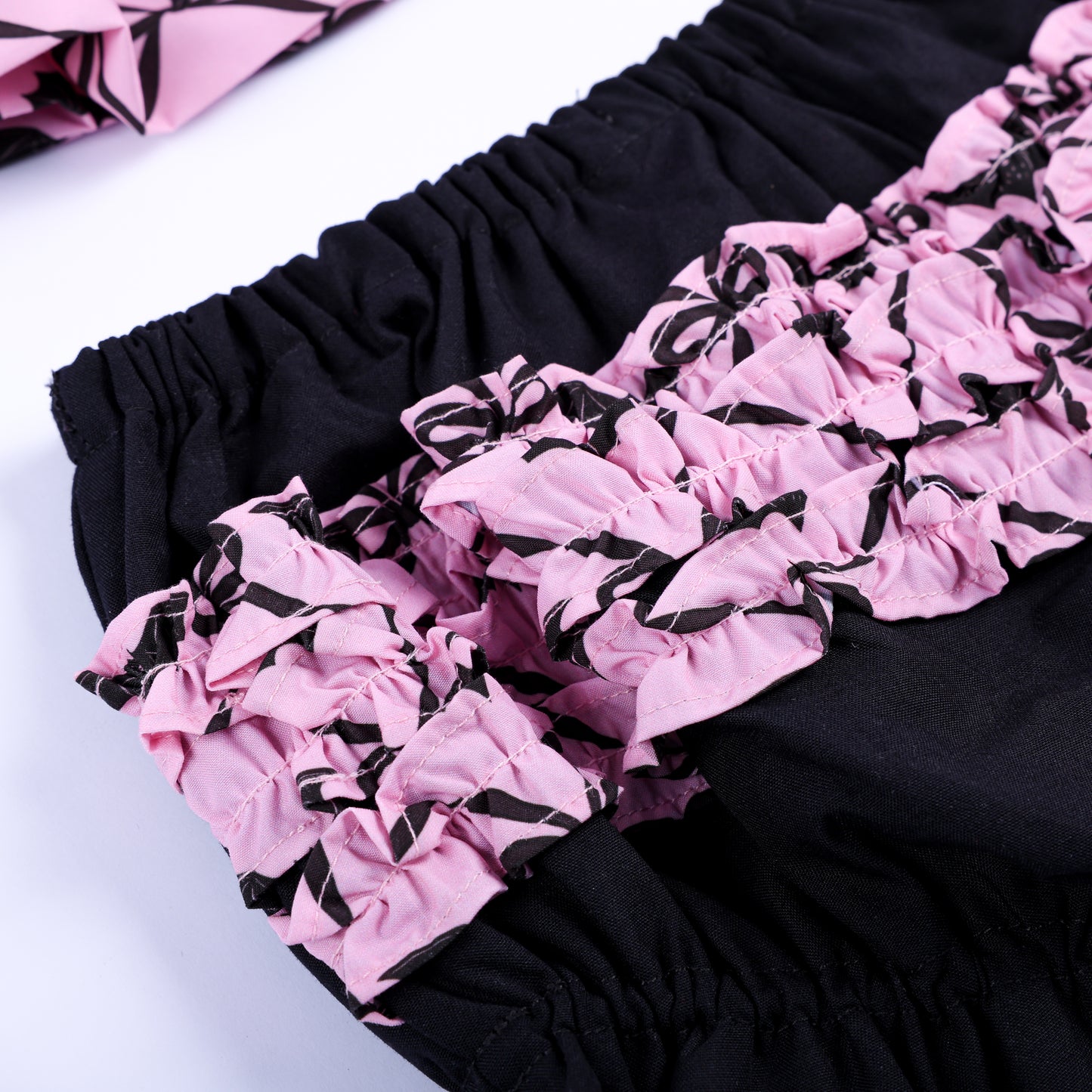 Detailed shot of pink bat pattern layered ruffles on back of black baby bloomers for Halloween outfit.