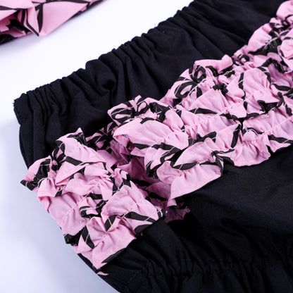 Detailed shot of pink bat pattern layered ruffles on back of black baby bloomers for Halloween outfit.