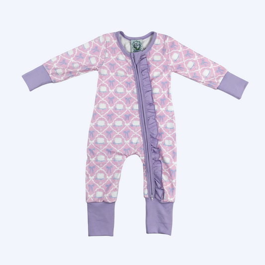 Flat lay view of the Birthday Cake and Bow Girl Zippy featuring ruffled zipper trim and lavender cuffs.