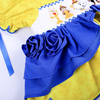 Handcrafted royal blue fabric rosettes layered over yellow rose print fabric on girls custom smocked outfit.