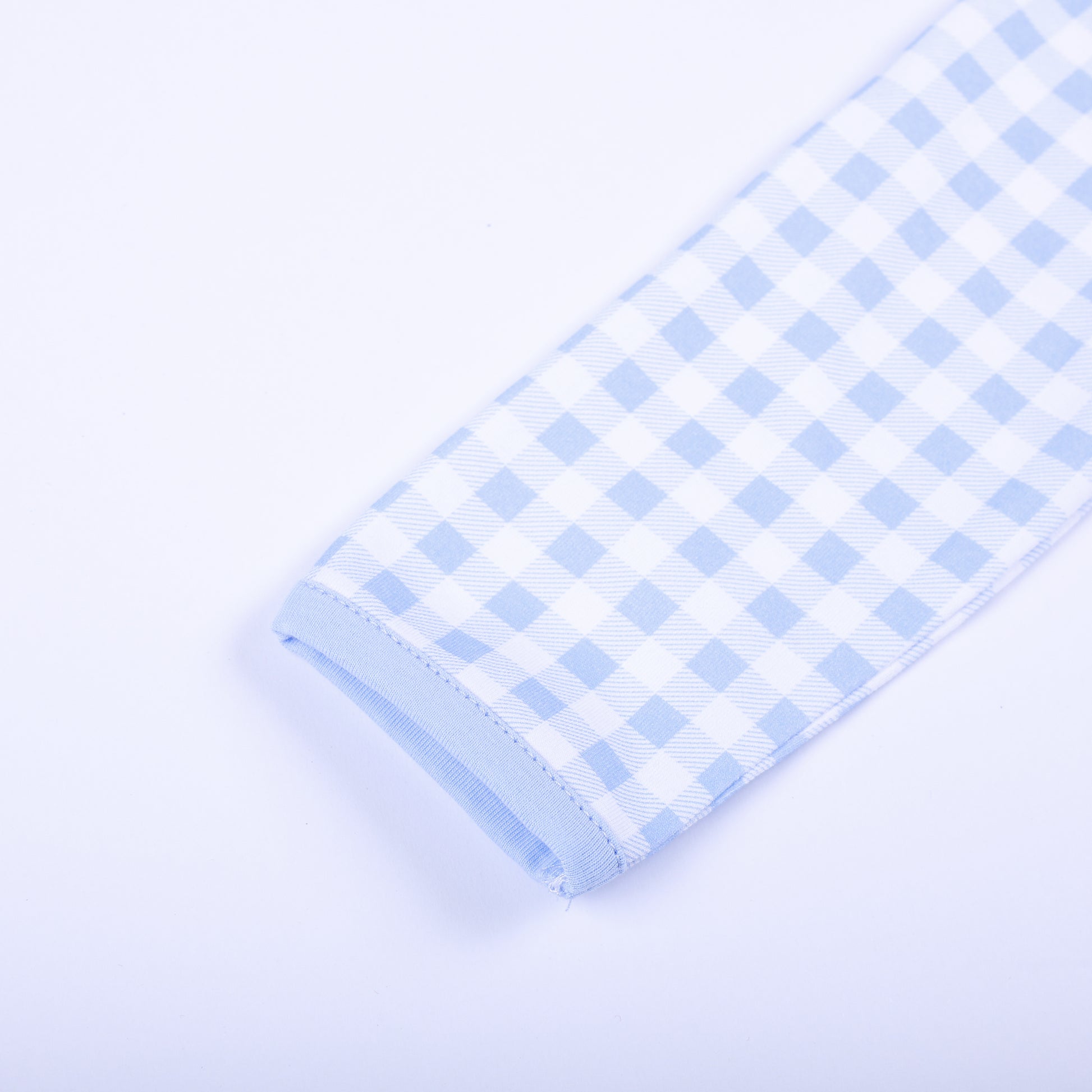 Detailed view of soft long sleeve cuff and light blue trim on baby gingham hand smocked sleep sack layette.