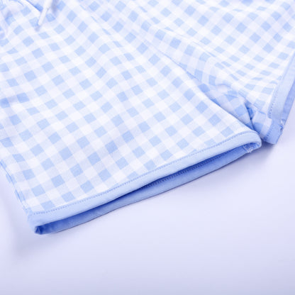 Close-up shot of neat hem stitching on light blue gingham shorts matching hand smocked Big Brother outfit.