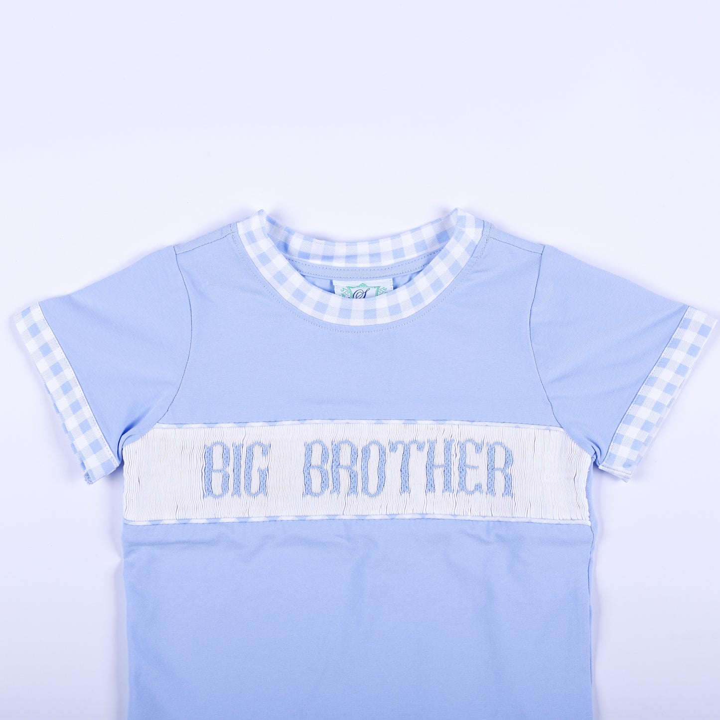 Close-up of light blue shirt featuring hand smocked Big Brother embroidered text panel and gingham collar trim.