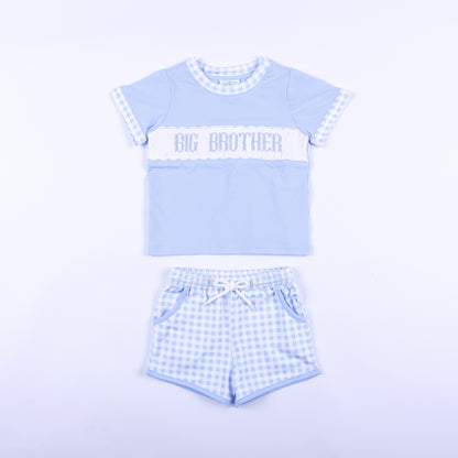 Front view of blue gingham big brother hand smocked shorts set with embroidered chest panel and matching shorts.