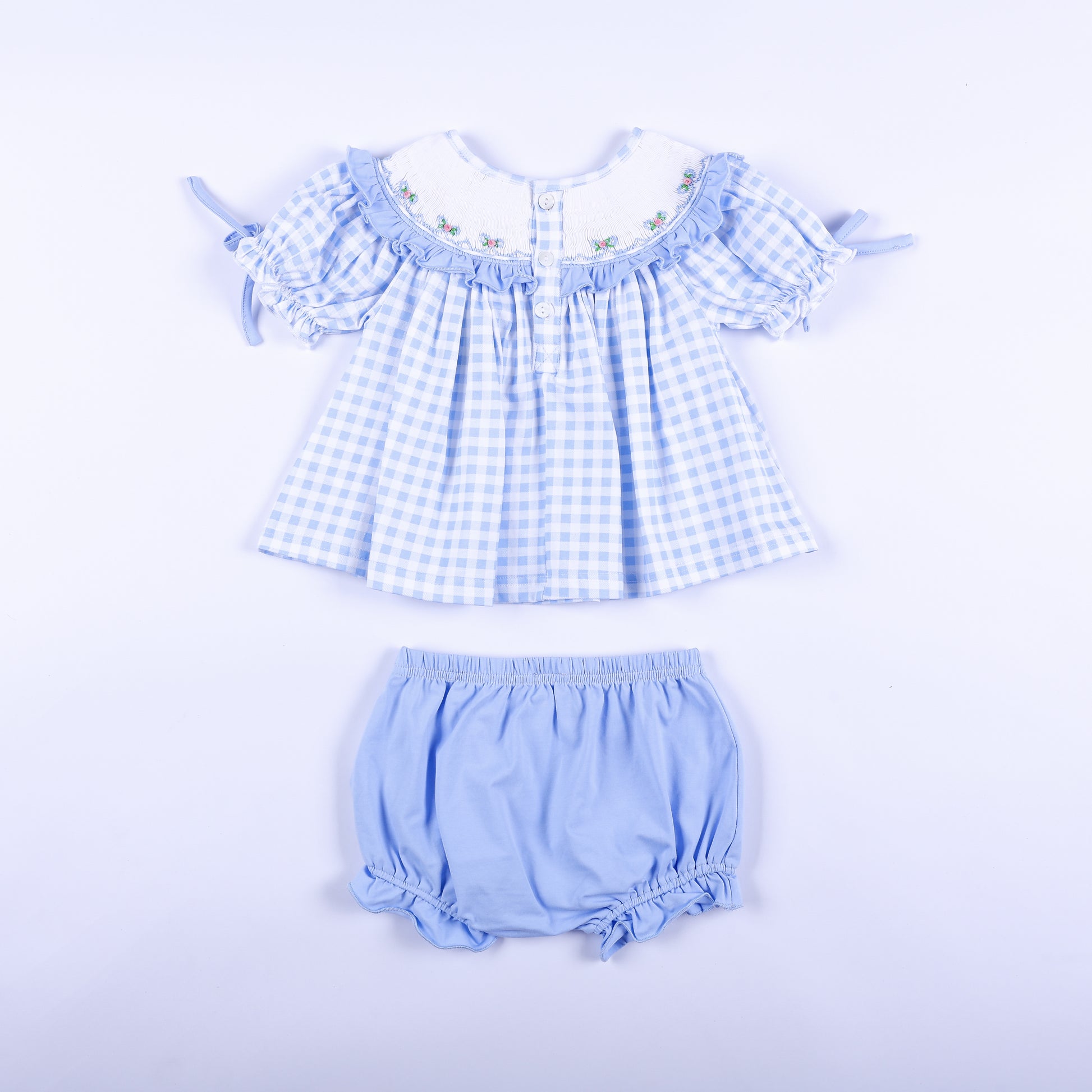 Back full set view of blue gingham hand-smocked Big Sister top with buttons and light blue bloomer set.
