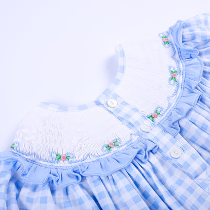 Close-up back view of a blue gingham smocked dress featuring white button closures and ruffled collar.
