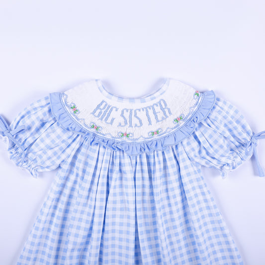 Close-up view of the hand-smocked neckline with Big Sister embroidery on a light blue gingham dress.