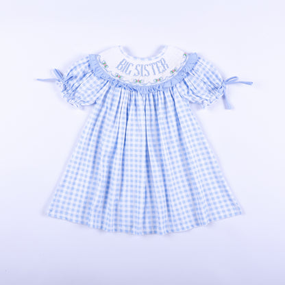 Front view of a light blue gingham big sister hand-smocked dress featuring delicate embroidery.