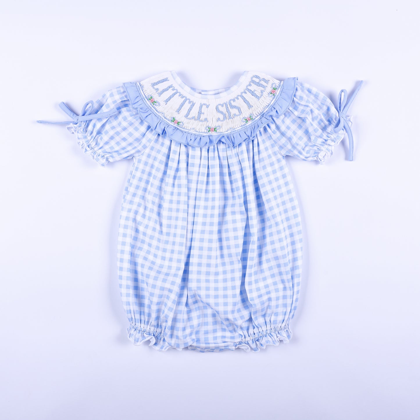 Front view of a blue gingham hand-smocked baby bubble outfit featuring Little Sister embroidery on the collar.