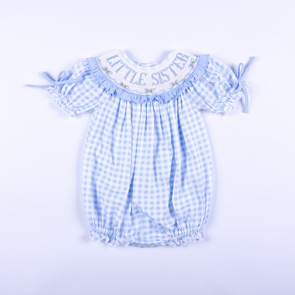 Front view of a blue gingham hand-smocked baby bubble outfit featuring Little Sister embroidery on the collar.