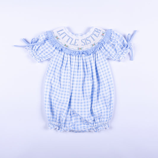 Front view of a blue gingham hand-smocked baby bubble outfit featuring Little Sister embroidery on the collar.