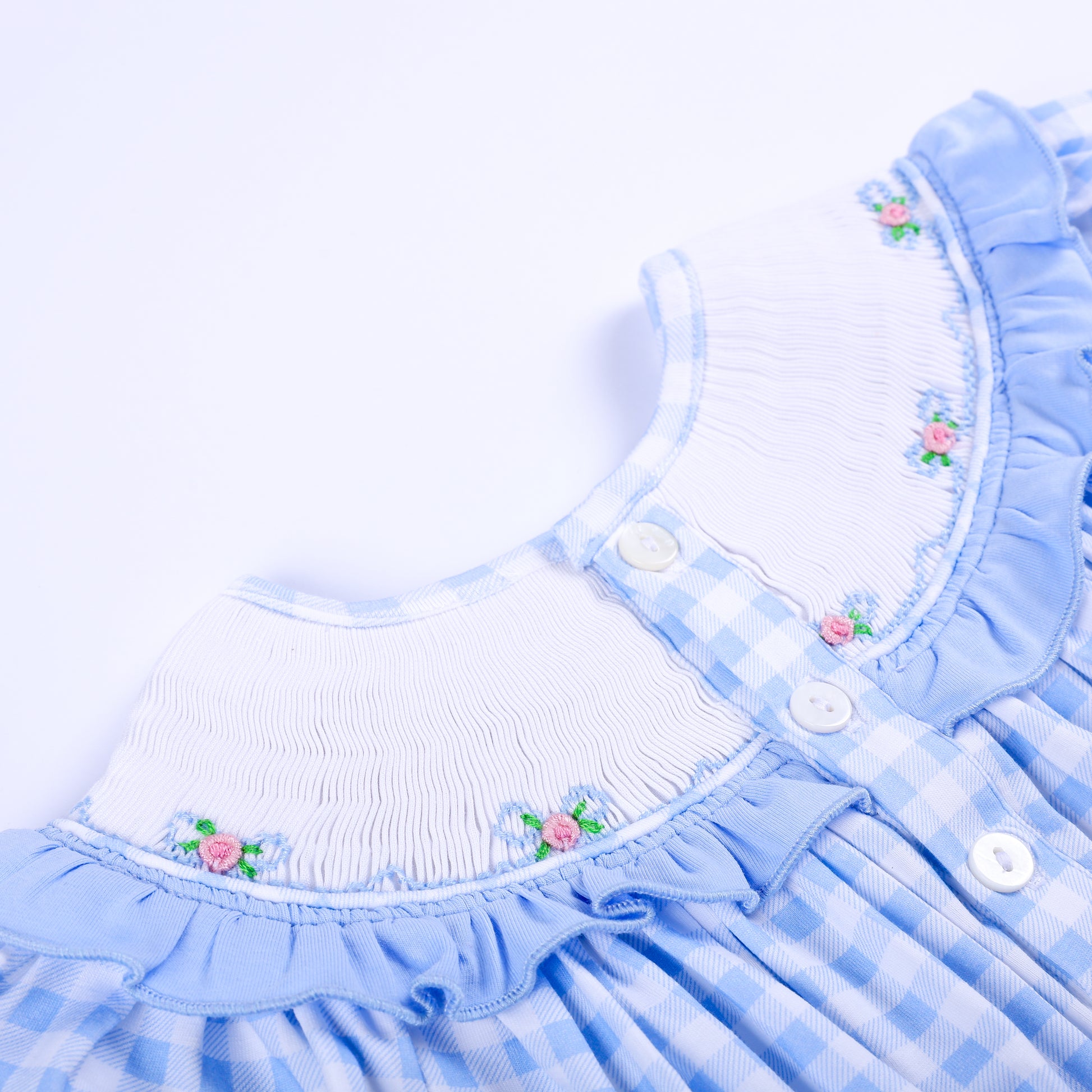 Close-up back view of a blue gingham hand-smocked bubble showing white button closure and embroidered collar.