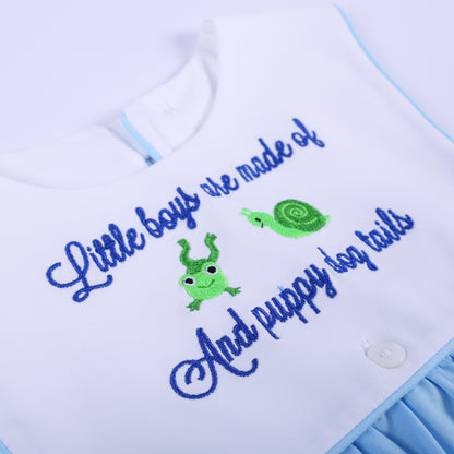 Detailed close-up of embroidered text reading Little Boys Are Made Of with cute green frog and snail.