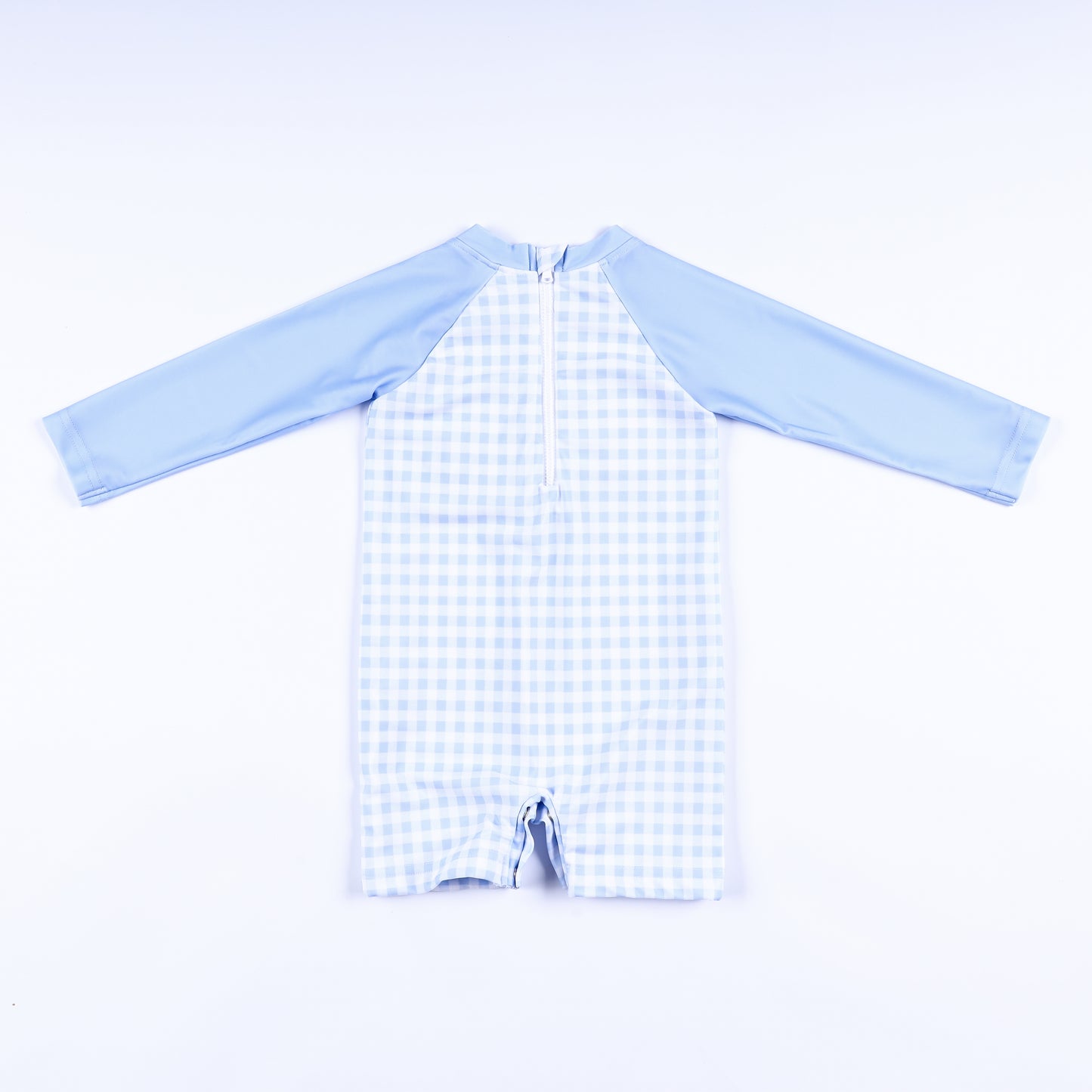 Back view of boys light blue gingham handsome prince hand smocked rash guard swimsuit with back zipper closure.