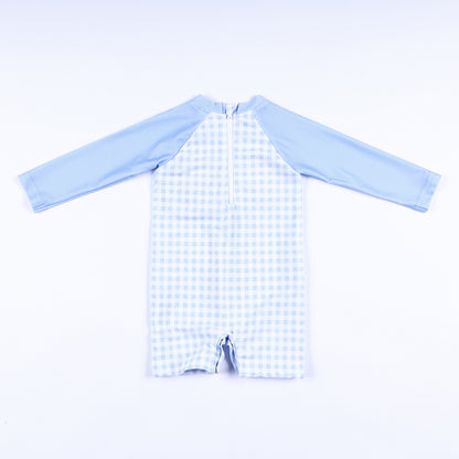 Back view of boys light blue gingham handsome prince hand smocked rash guard swimsuit with back zipper closure.
