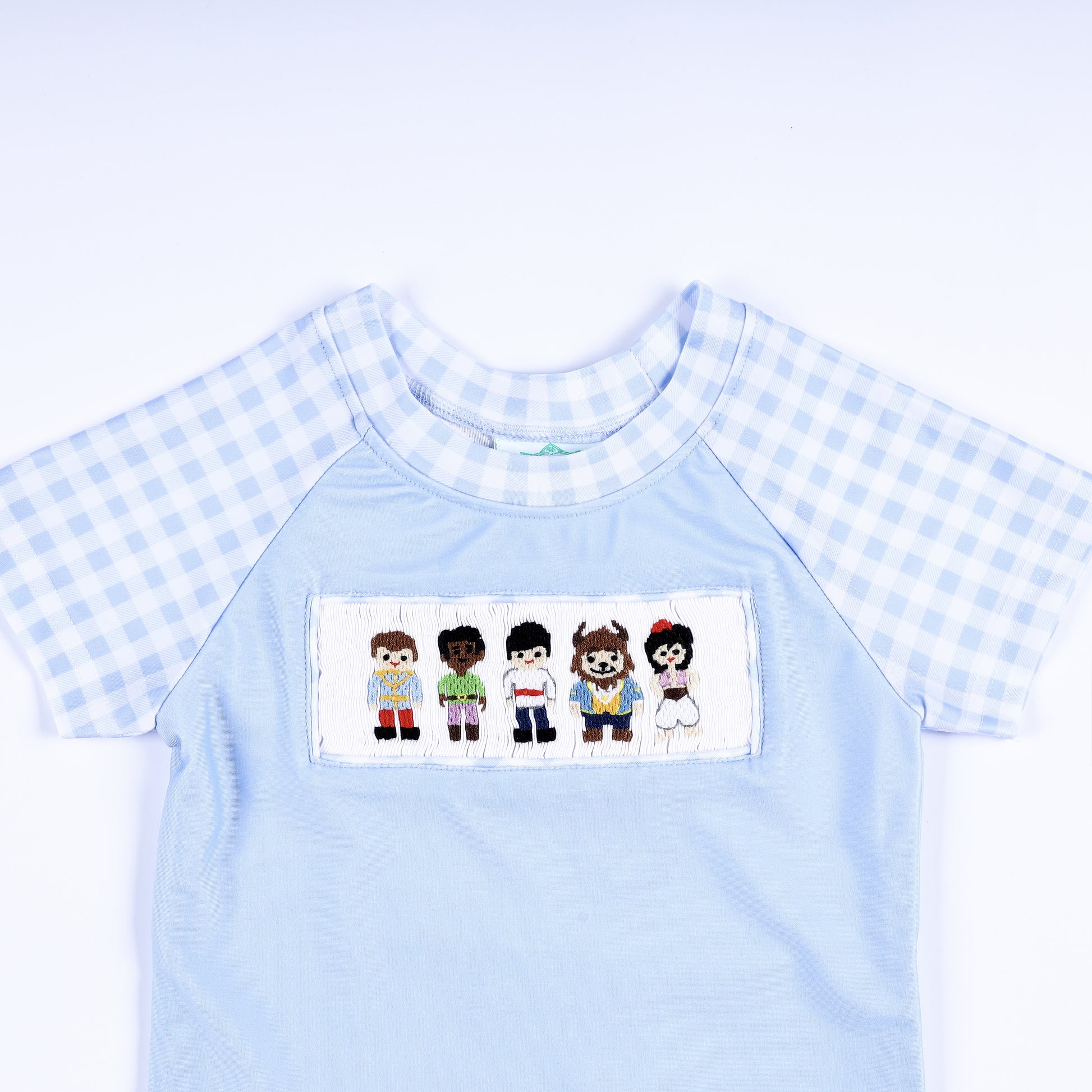 Boys light blue rash guard shirt featuring hand smocked prince embroidered chest plate and gingham short sleeves.