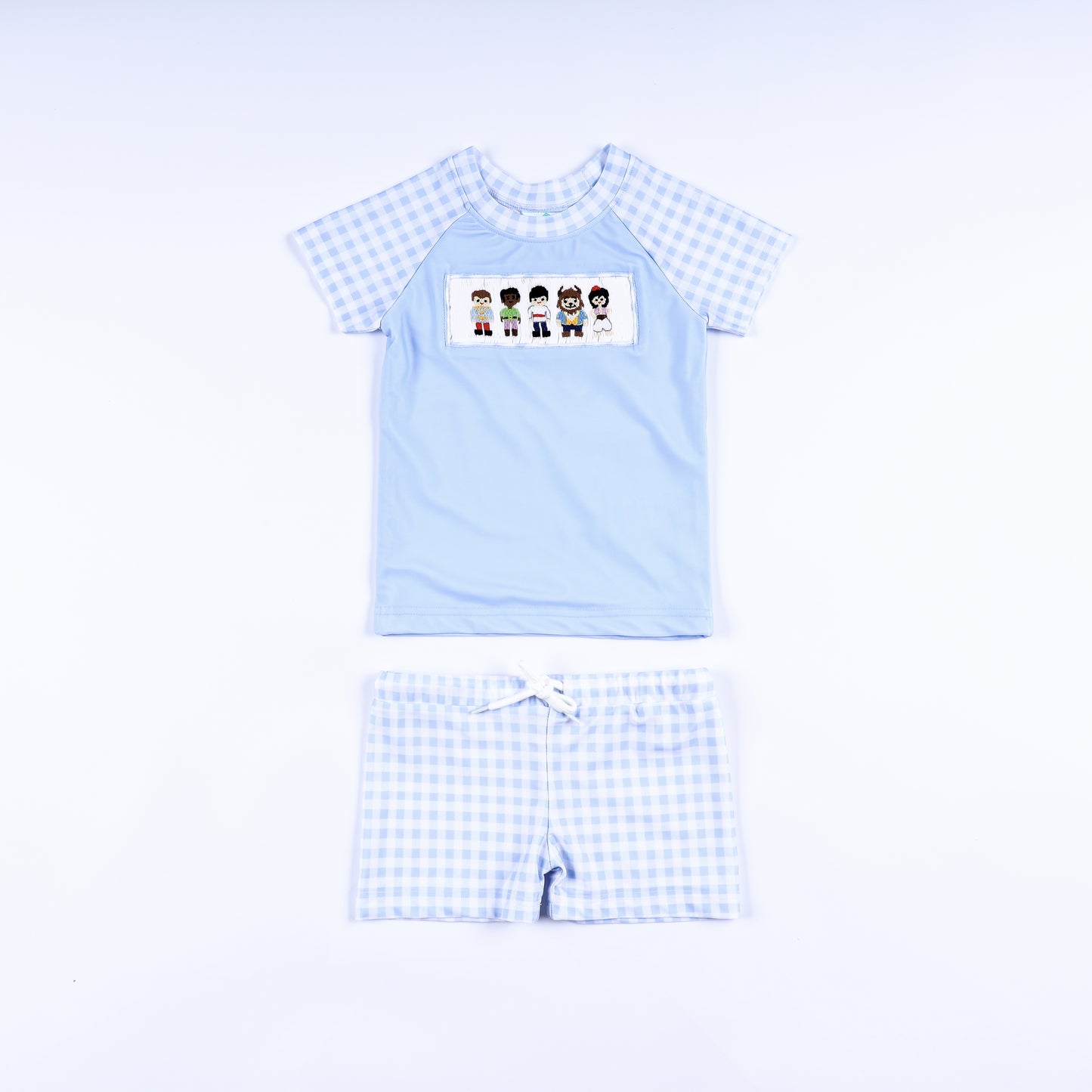 Boys handsome prince hand smocked two piece rash guard swimsuit with light blue top and gingham swim trunks front view.