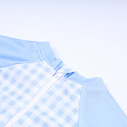 Close-up detail of back zipper closure on boys handsome prince hand smocked gingham one piece rash guard swimsuit.