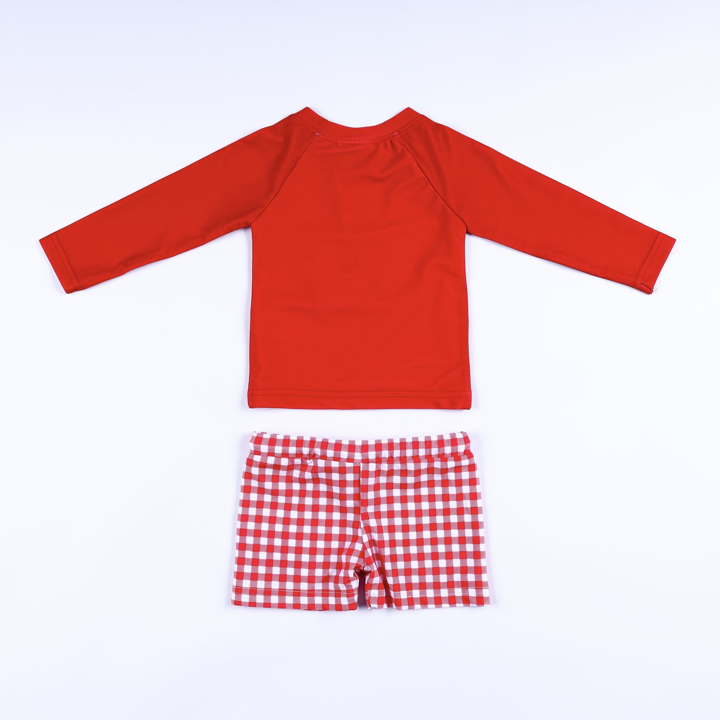 Back view of the boys red long sleeve swim rash guard top and matching red and white gingham swim trunks.