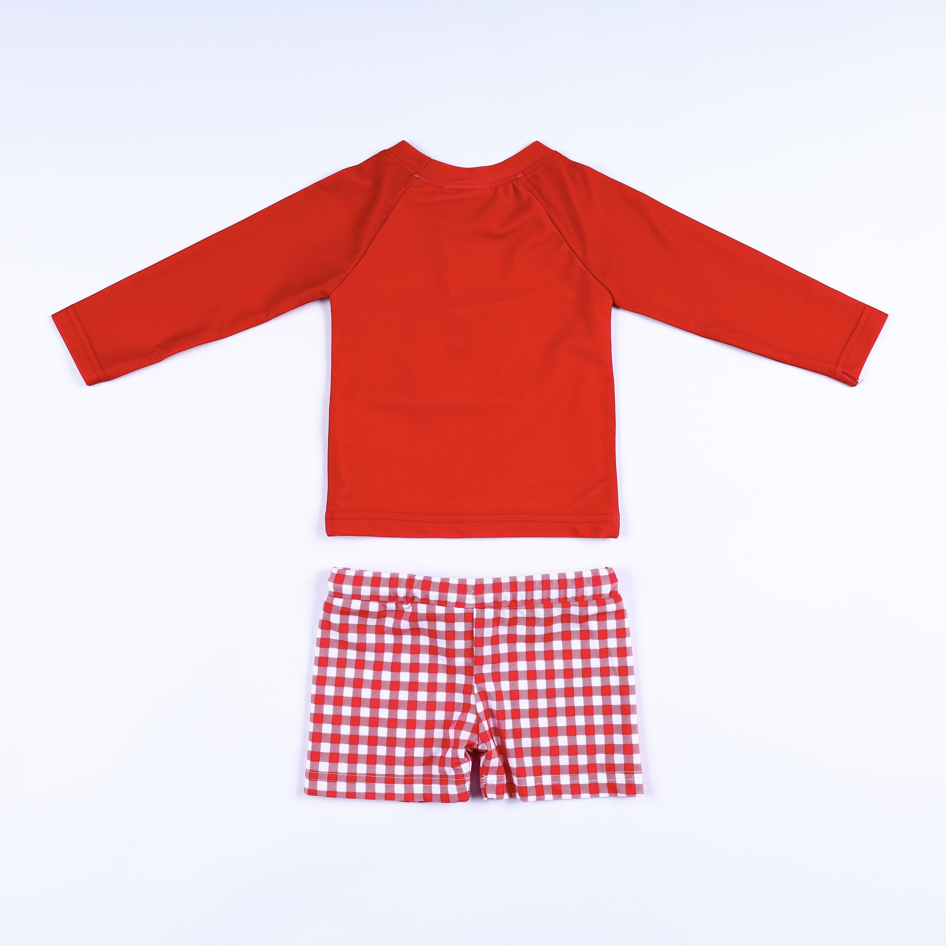 Back view of the boys red long sleeve swim rash guard top and matching red and white gingham swim trunks.